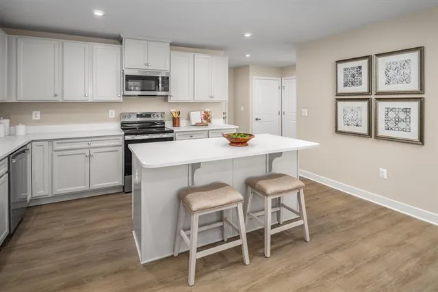 a kitchen with a dining table chairs and wooden floor