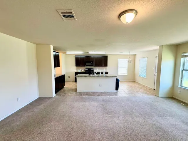 a view of kitchen with microwave oven stove and cabinets