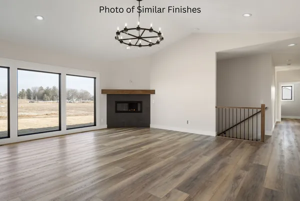 a kitchen with stainless steel appliances a refrigerator a stove a microwave and white cabinets with wooden floor