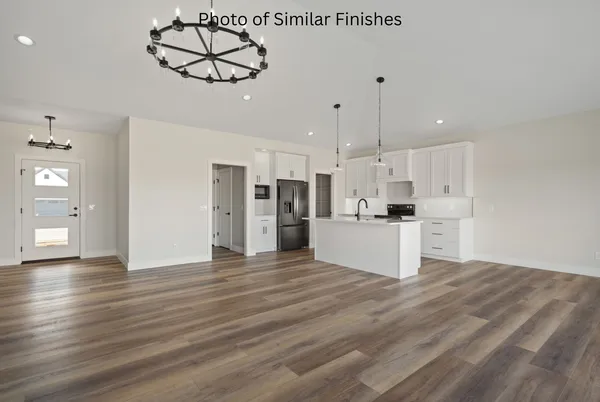 a kitchen with stainless steel appliances a refrigerator stove and white cabinets with wooden floors