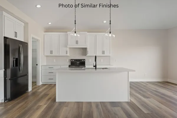 a kitchen with stainless steel appliances granite countertop a sink a stove and a wooden floors
