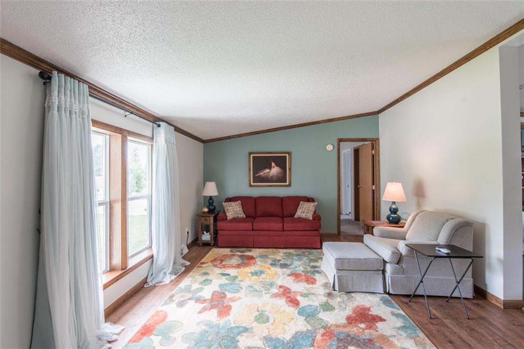 The living room is bright and airy with a large picture window and vaulted ceiling. 