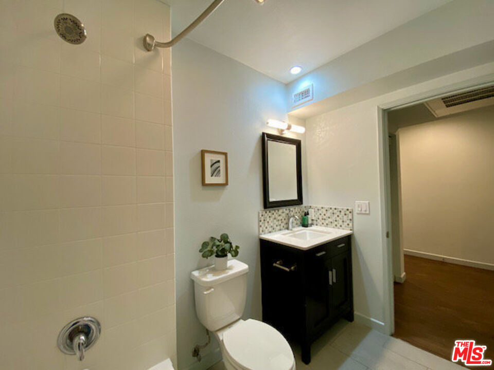 1920 Hillcrest Road, Unit 5 Los Angeles, CA 90068 - Photo 14 of 17 a bathroom with a granite countertop sink toilet and mirror