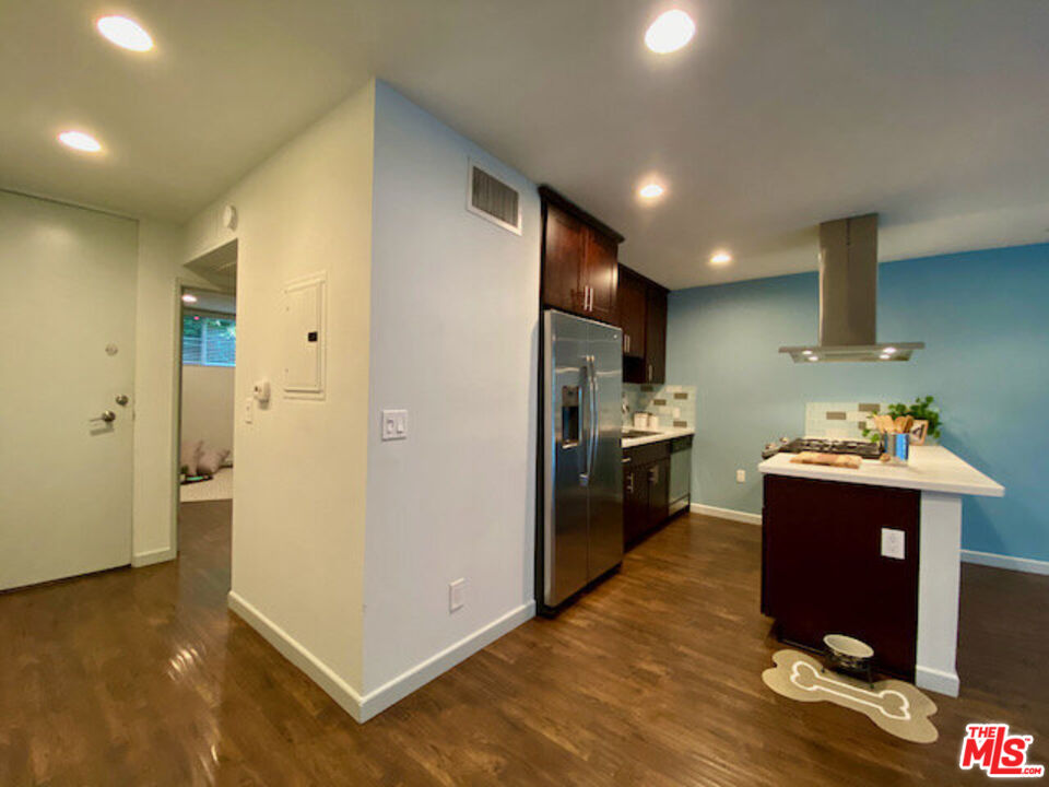 1920 Hillcrest Road, Unit 5 Los Angeles, CA 90068 - Photo 9 of 17 a kitchen with kitchen island granite countertop wooden cabinets and stainless steel appliances