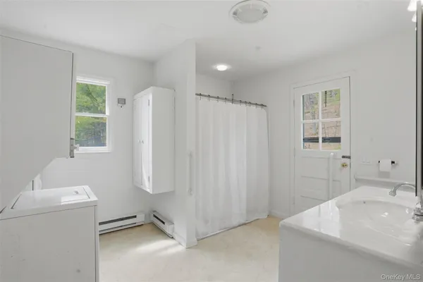 a bathroom with a sink a toilet and shower