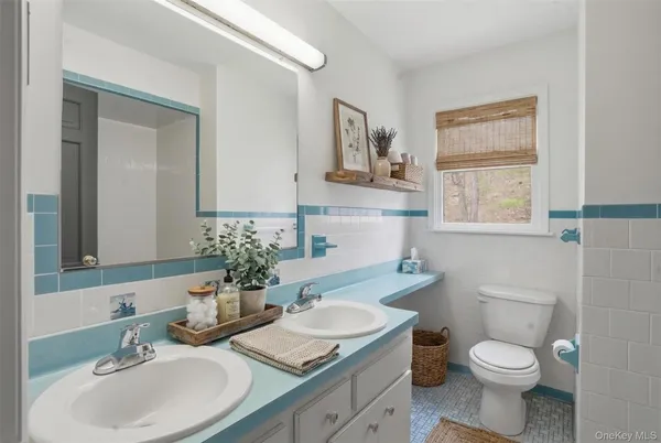 a bathroom with a granite countertop toilet sink and mirror