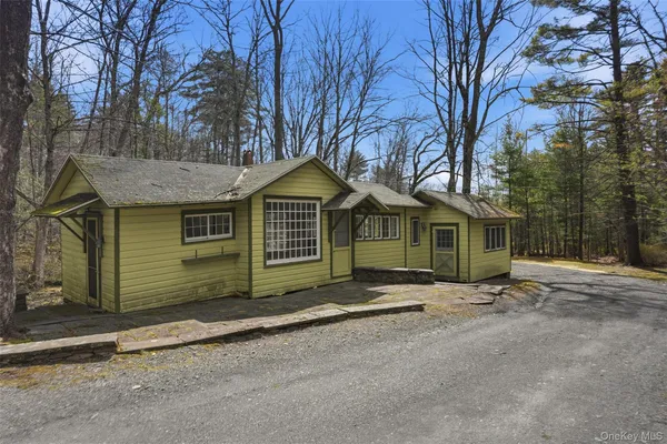 a view of a house with a yard and large tree