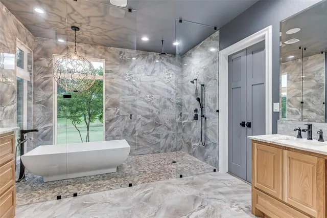 a spacious bathroom with a granite countertop sink a toilet a bathtub and shower
