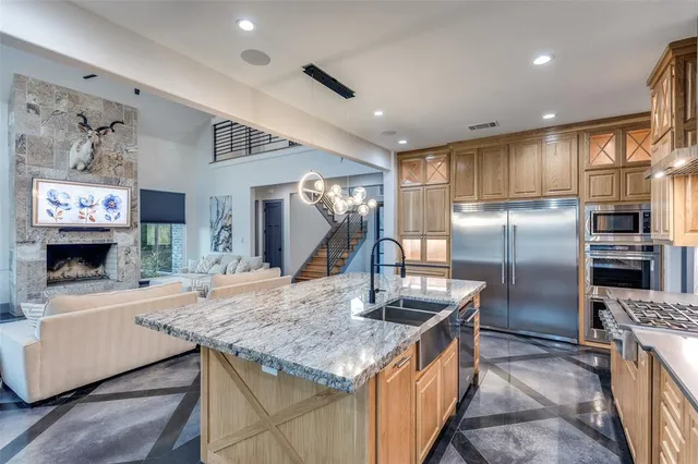 a kitchen with stainless steel appliances granite countertop a sink and a refrigerator