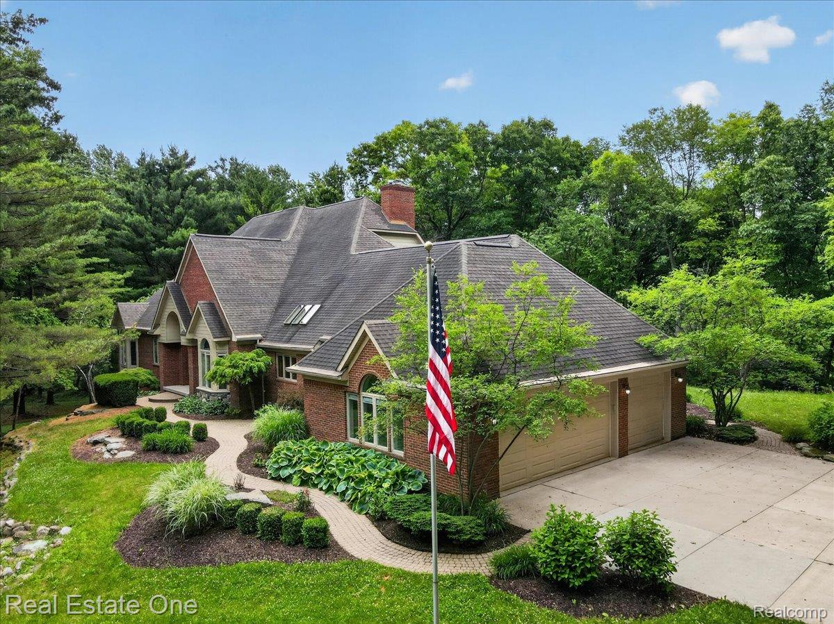 425 Courtney Road Leonard, MI 48367 - Photo 2 of 89 Brick exterior residence featuring a two-car garage, concrete driveway, and front walk