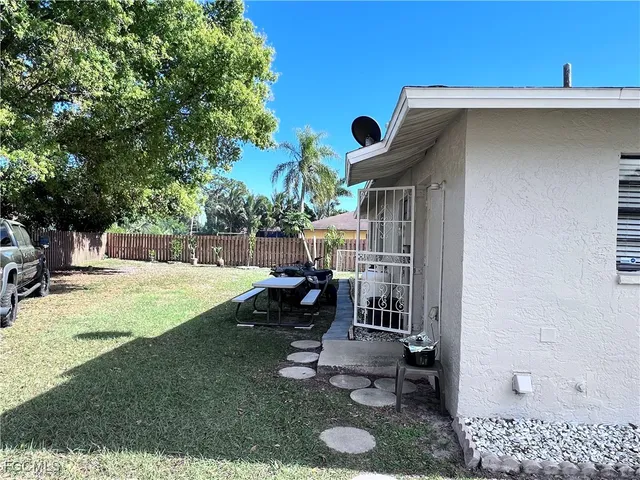 a view of a house with backyard and sitting area