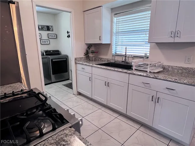a kitchen with granite countertop a stove and a sink