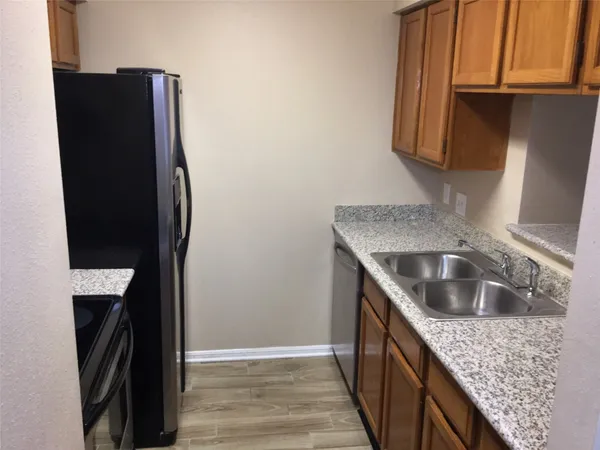 a kitchen with stainless steel appliances granite countertop a refrigerator and a sink