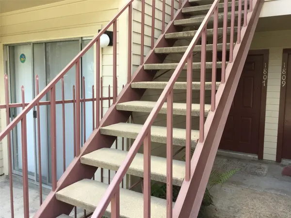 a view of staircase with wooden floor and white walls