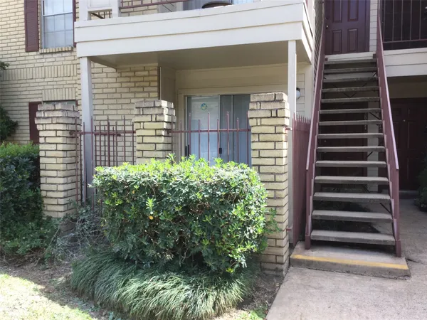a view of a house with a window and potted plants