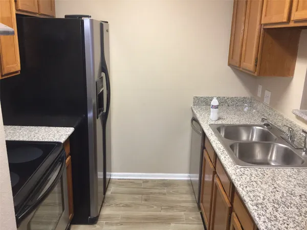 a kitchen with stainless steel appliances granite countertop a refrigerator and a sink