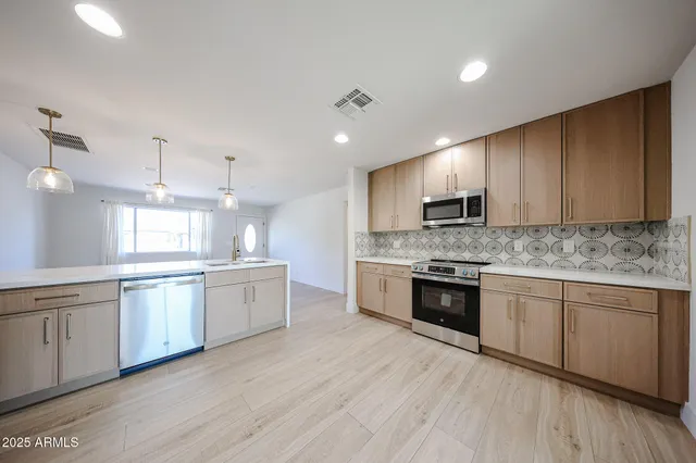 a large kitchen with granite countertop a stove top oven sink and cabinets