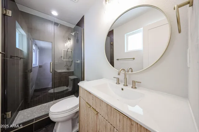 a bathroom with a sink a toilet and shower