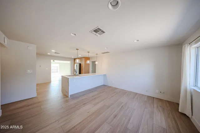 an empty room with wooden floor and a window
