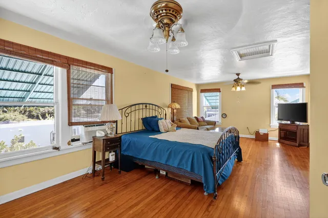 a view of a room with wooden floor fan and windows