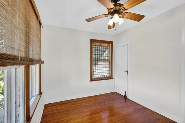 a bedroom with bed and a large mirror on the dresser