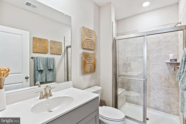 a bathroom with a sink a toilet a shower and a mirror