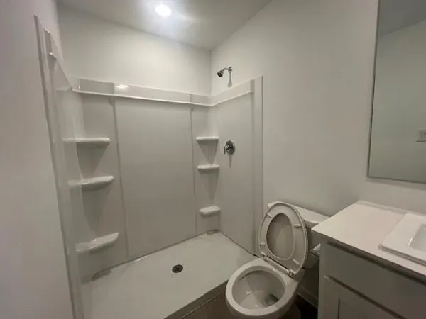 a bathroom with a granite countertop sink toilet and shower