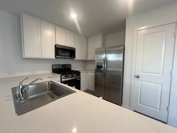 a kitchen with granite countertop a refrigerator and a sink
