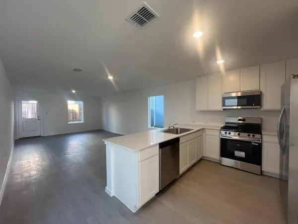 a kitchen with stainless steel appliances granite countertop a stove a sink and a refrigerator