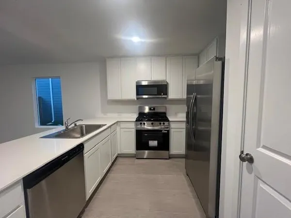 a kitchen with a sink stove and refrigerator