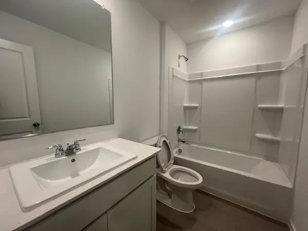 a bathroom with a granite countertop sink a toilet and a bathtub