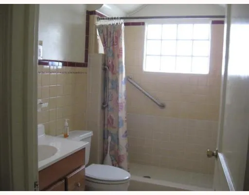 a bathroom with a granite countertop bathtub shower sink and toilet