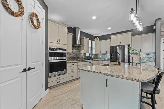 a kitchen with stainless steel appliances granite countertop a stove a sink and a refrigerator