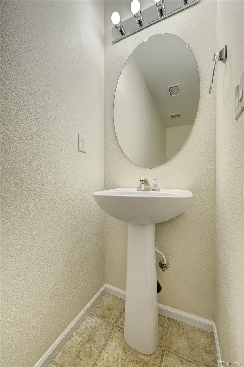 20527 Robins Drive Denver, CO 80249 - Photo 12 of 25 a bathroom with a sink a mirror and vanity