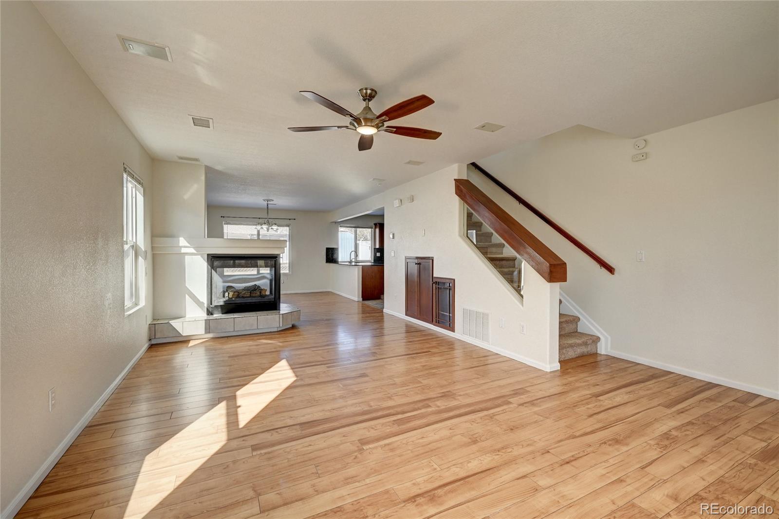 20527 Robins Drive Denver, CO 80249 - Photo 3 of 25 a view of a livingroom with wooden floor a ceiling fan and staircase