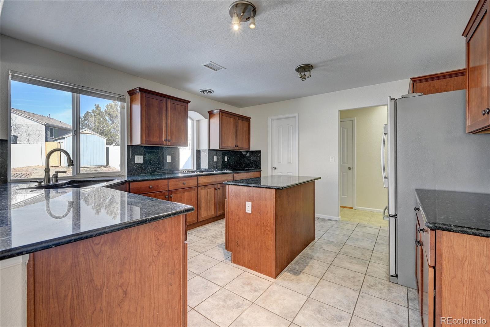 20527 Robins Drive Denver, CO 80249 - Photo 9 of 25 a kitchen with stainless steel appliances granite countertop a sink a stove and a refrigerator
