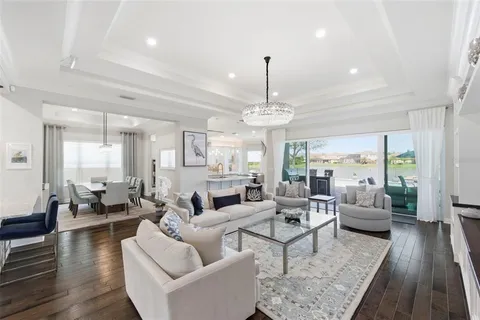 a kitchen that has a lot of white cabinets and stainless steel appliances