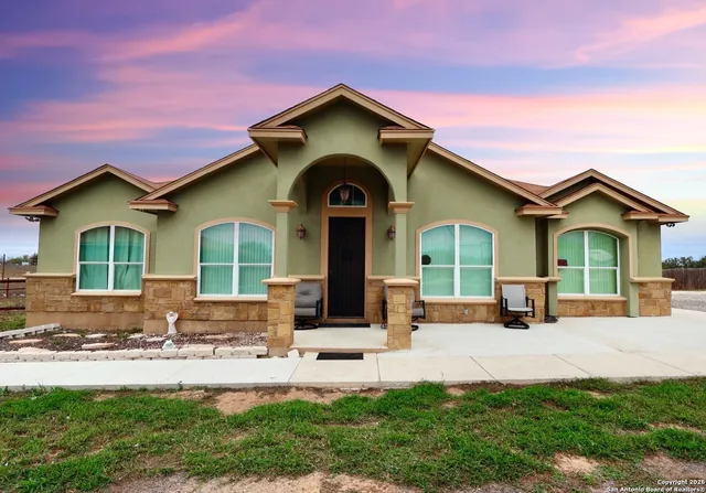 a front view of a house with yard and green space