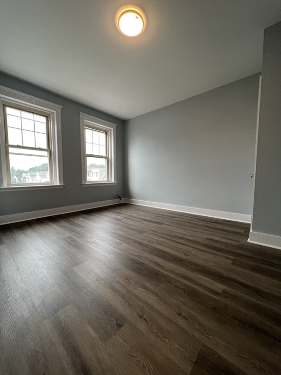 47 Hooker Street, Unit 3 Boston, MA 02134 - Photo 5 of 10 an empty room with wooden floor and windows
