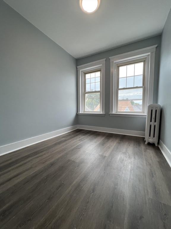 47 Hooker Street, Unit 3 Boston, MA 02134 - Photo 6 of 10 an empty room with wooden floor and windows