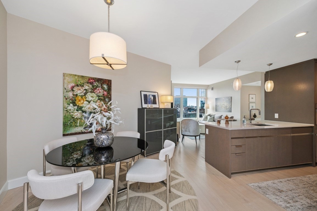 100 Lovejoy Wharf, Unit PH 2C Boston, MA 02114 - Photo 1 of 30 a living room with furniture a dining table and a chandelier