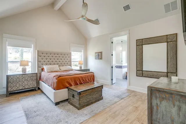 a spacious bedroom with a bed and a mirror