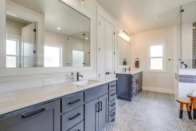 a spacious bathroom with a tub sink and mirror