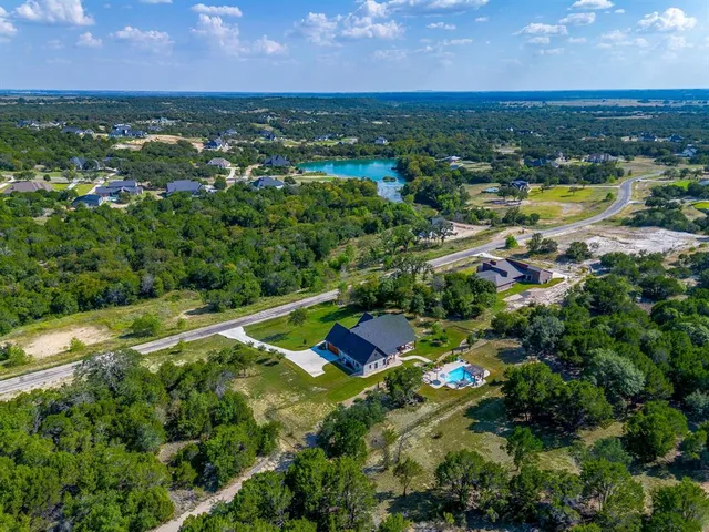 an aerial view of residential houses with outdoor space and river