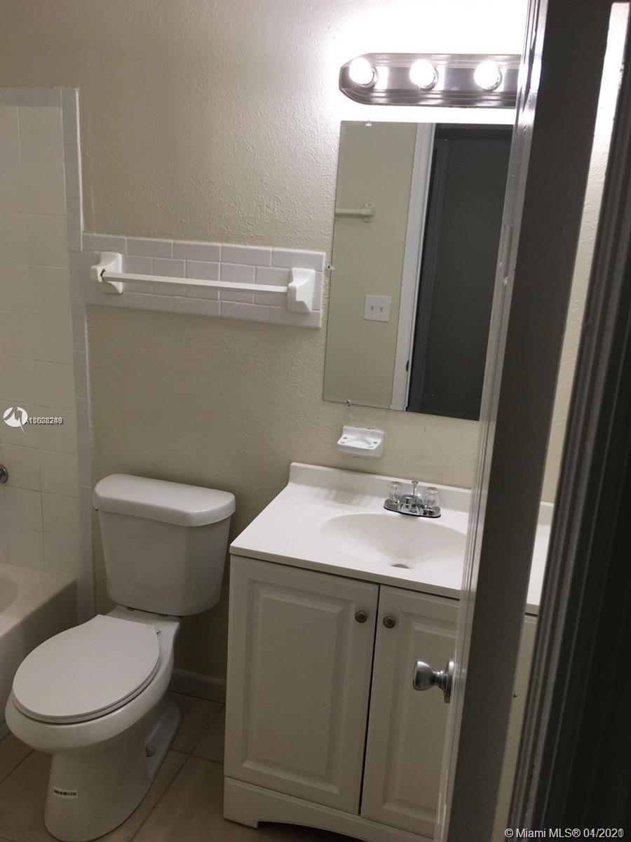 401 Southwest 13th Place, Unit 720 Deerfield Beach, FL 33441 - Photo 15 of 20 a bathroom with a sink a toilet and a mirror