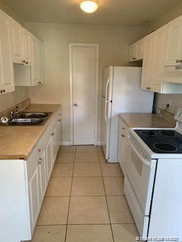 401 Southwest 13th Place, Unit 720 Deerfield Beach, FL 33441 - Photo 6 of 20 a kitchen with a stove sink and cabinets