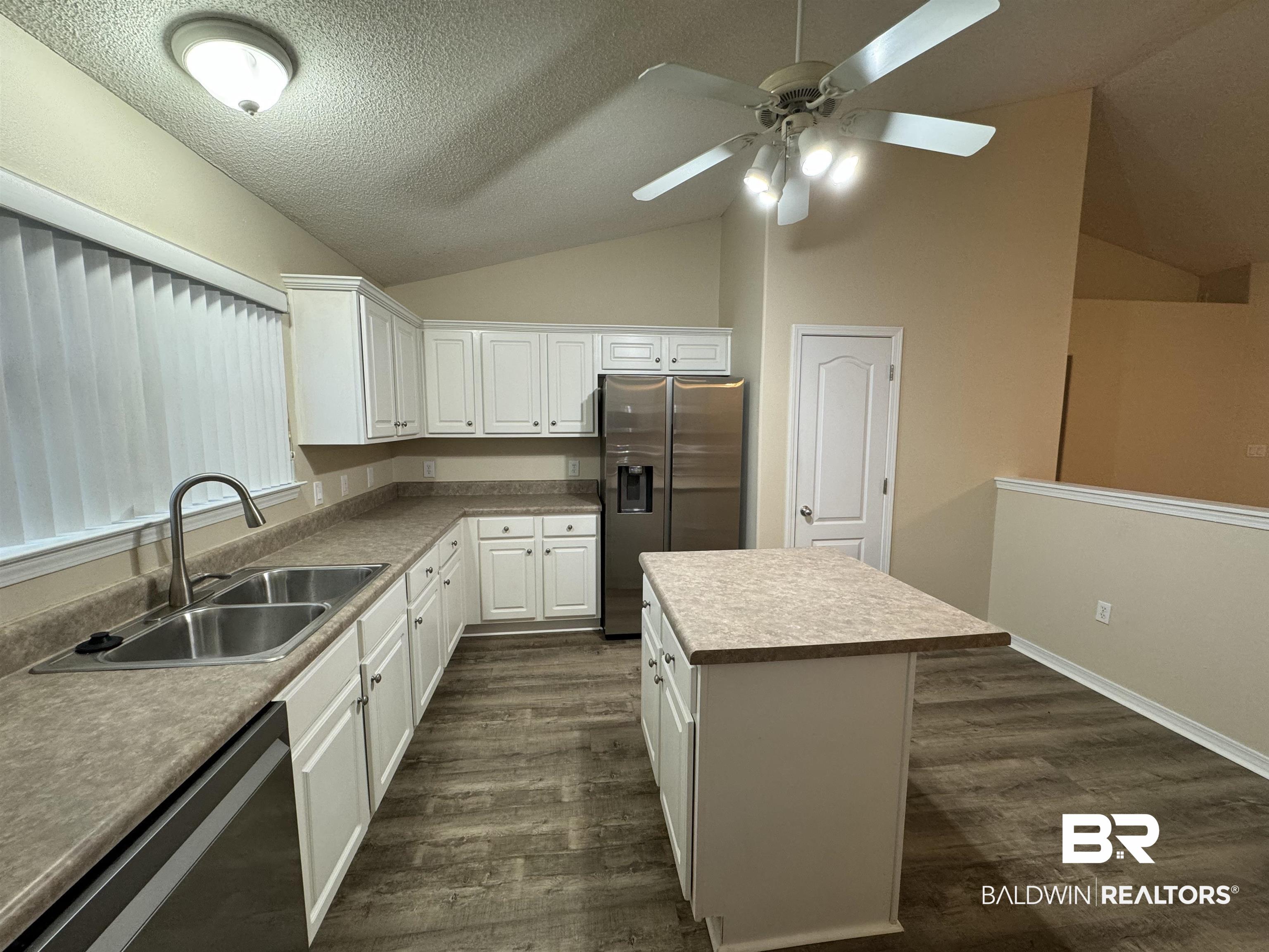 32769 Arbor Ridge Circle Lillian, AL 36549 - Photo 7 of 36 Kitchen featuring vaulted ceiling, sink, stainless steel appliances, dark hardwood / wood-style floors, and white cabinetry