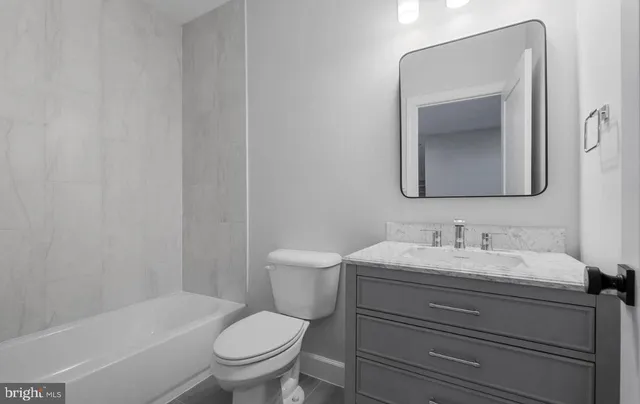 a bathroom with a toilet a sink and mirror