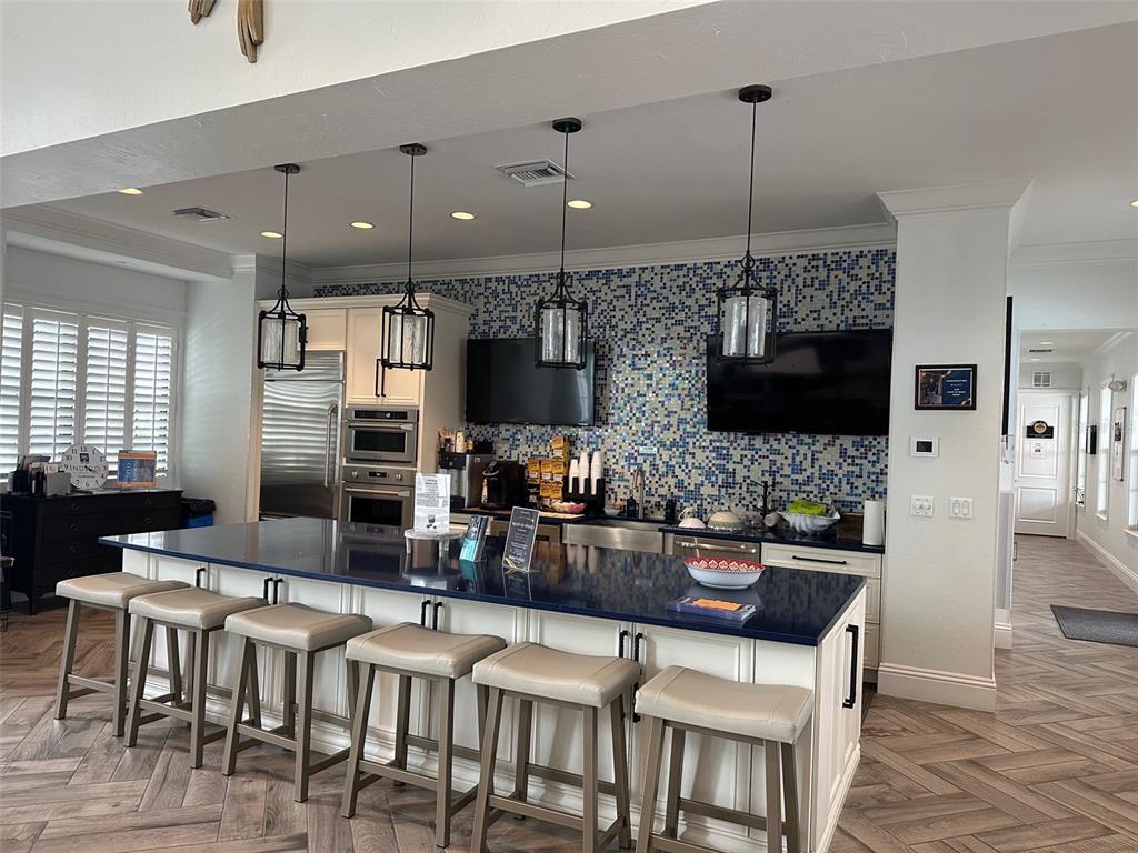 3511 Azurite Way Bradenton, FL 34211 - Photo 57 of 64 a kitchen with stainless steel appliances kitchen island granite countertop a dining table chairs and a refrigerator