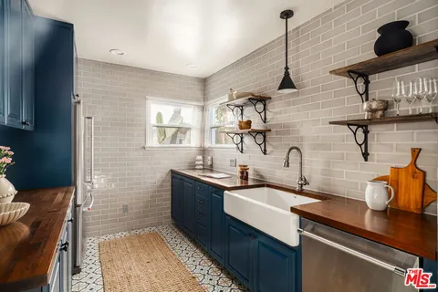a kitchen with sink a mirror and cabinets
